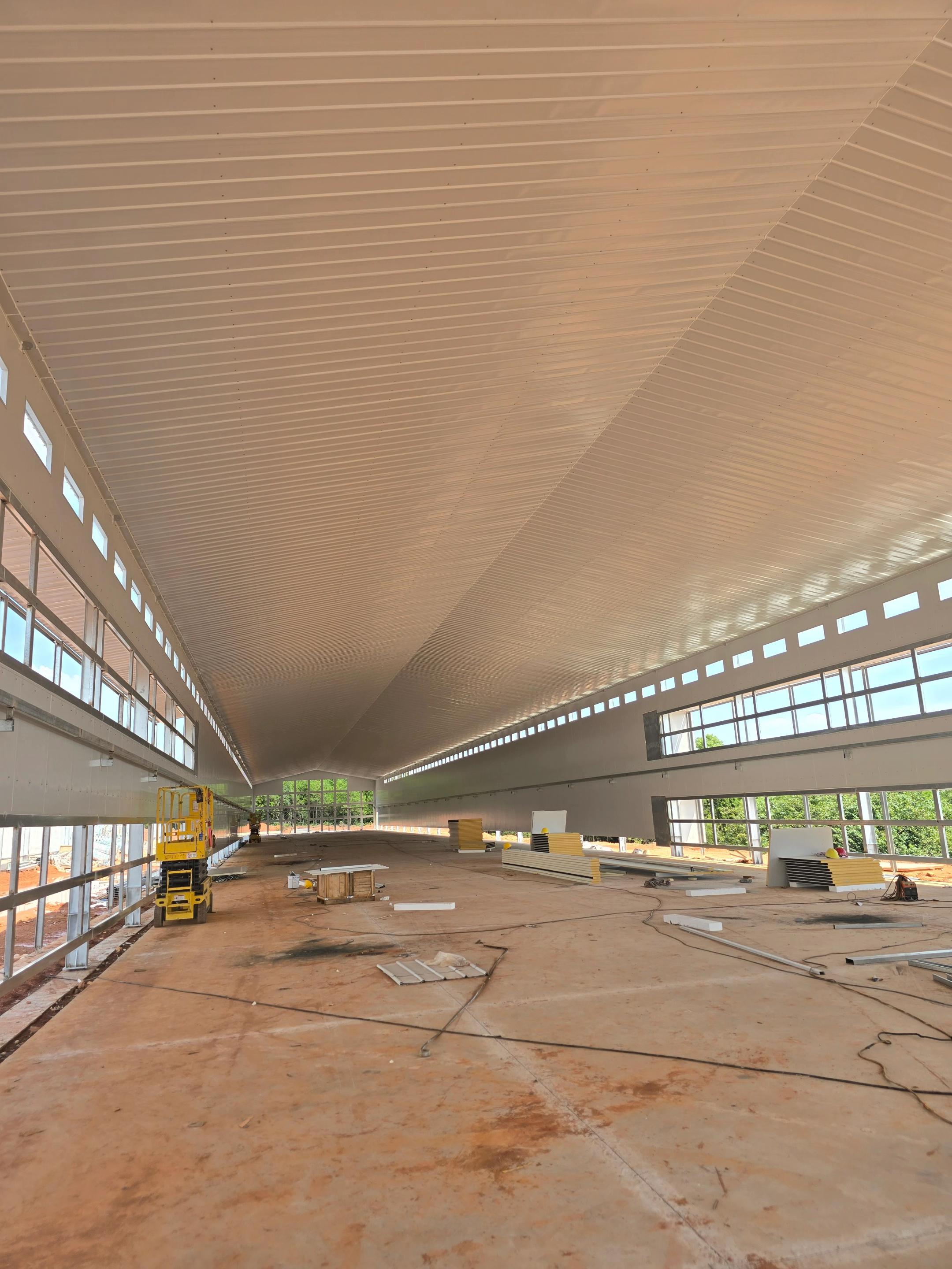 Poultry house interior under construction with a scissor lift in Luzon, Philippines